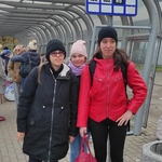 Uczennice stoją  na przystanku autobusowym