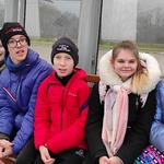 Uczniowie siedzą na przystanku autobusowym