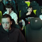 Grupa uczniów siedzi na fotelach w kinie