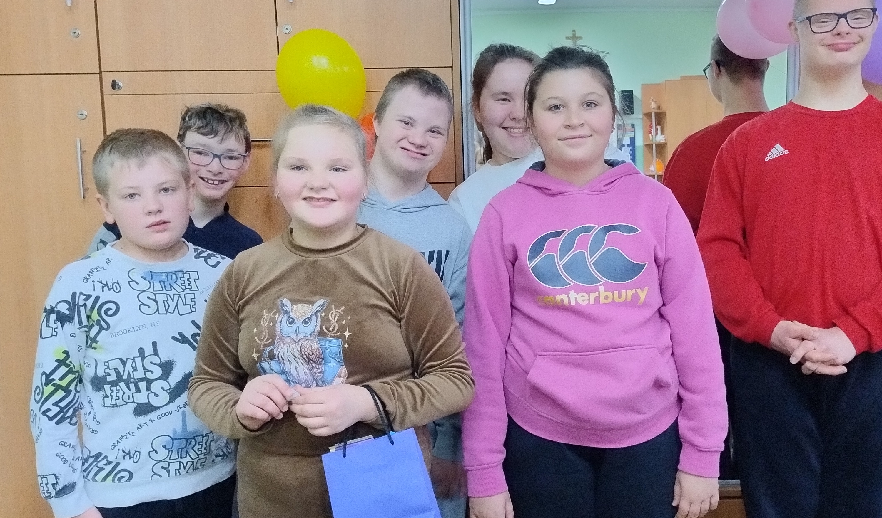 Jubilatka, jej koledzy i koleżanki z klasy pozują do pamiątkowego zdjęcia