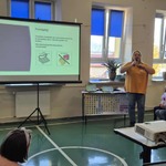 Nauczycielki mówią do uczniów siedzących na ławeczkach