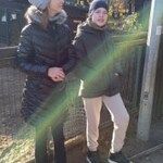 Uczeń i uczennica stoją przy ogrodzeniu