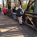Uczeń stoi przy płocie w parku