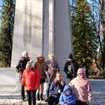 Grupa uczniów na tle pomnika