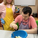 Uczeń wkłada pokrojone jabłka do miski
