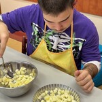 Uczeń wkłada pokrojone jabłka do małej tartaletki