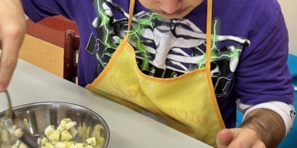 Uczeń wkłada pokrojone jabłka do małej tartaletki