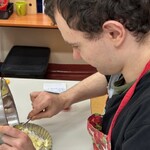 Uczeń wkłada pokrojone jabłka do małej tartaletki