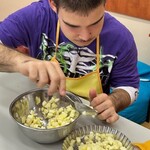 Uczeń wkłada pokrojone jabłka do małej tartaletki