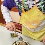 Uczeń posypuje kruszonką pokrojone jabłka