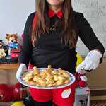 Nauczycielka w przebraniu Myszki Miki trzyma talerz z ciasteczkami