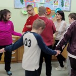 Grupa uczniów tańczy w kole.