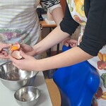Uczniowie wbijają jajko do miski