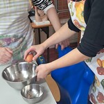 Uczniowie wbijają jajko do miski