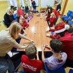 Warsztaty świeczek. Uczniowie siedzą wokół stołu