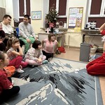Nauczyciel przebrany za Świętego Mikołaja, uczniowie obserwują