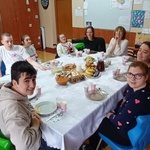 Nauczycielki i uczniowie siedzą przy wigilijnym stole