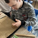 Uczeń formuje dłonią ciastko na blasze