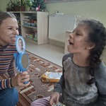 Uczennica wykonuje ćwiczenie. Patrzy w lusterko trzymane przez nauczycielkę
