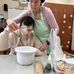 Uczeń odmierza cukier i wsypuje do miski