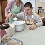 Uczeń odmierza mąkę i wsypuje do miski