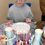 Solenizantka patrzy na tort urodzinowy