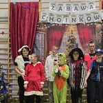 Nauczycielka, pomoc i uczniowie w strojach karnawałowych na tle dekoracji