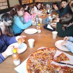 Uczestnicy półkolonii siedzą przy stole w pizzerni