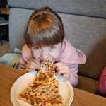 Dziewczynka je pizzę