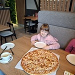 Uczennice siedzą przy stole na którym stoi pizza