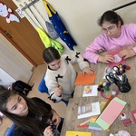 Uczniowie przy stole, na którym rozłożone są artykuły papiernicze.