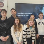 Grupa uczniów na tle wyświetlanego slajdu z napisem Dzień Bezpiecznego Internetu 2026