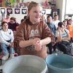 Uczennica w trakcie doświadczenia z ciepła i zimną wodą