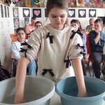 Uczennica w trakcie doświadczenia z ciepła i zimną wodą