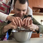 Uczeń z pomocą nauczyciela rozbija jajko