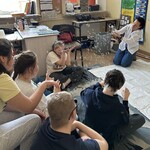 Nauczyciel puszcza bańki, uczniowie siedzą, próbują je złapać