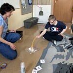 Uczeń uderza łapką na muchy w przezroczystą koszulkę, w której jest pianka