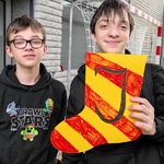Uczniowie prezentują pomalowaną skarpetkę