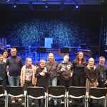 Grupa osób na scenie pozuje do wspólnej fotografii