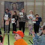 Grupa uczniów stoi i trzyma kartki z wydrukowanymi symbolami