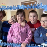 Nauczycielka, i czwórka uczniów w niebieskiej ramce z napisem - Światowy Dzień Świadomości Autyzmu