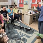 Nauczyciel wypuścił z rąk balon, uczniowie siedząc na krzesłach uśmiechają się, obserwują, jak fruwanie po klasie