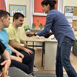 Nauczyciel trzyma pojemnik z przyprawą, uczeń wącha
