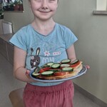 Uczennica trzyma talerz z kanapkami