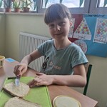 Uczennica smaruje masłem chleb