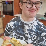 Uczeń trzyma talerz z naleśnikami