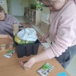 Uczennica wsypuje ziemię do doniczki