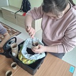 Uczennica wsypuje łyżką ziemię do doniczki
