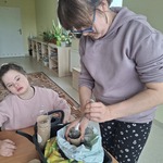 Uczennica wsypuje łyżką ziemię do doniczki