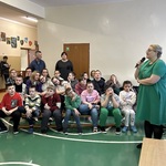 Nauczycielka mówi do uczniów biorących udział w apelu